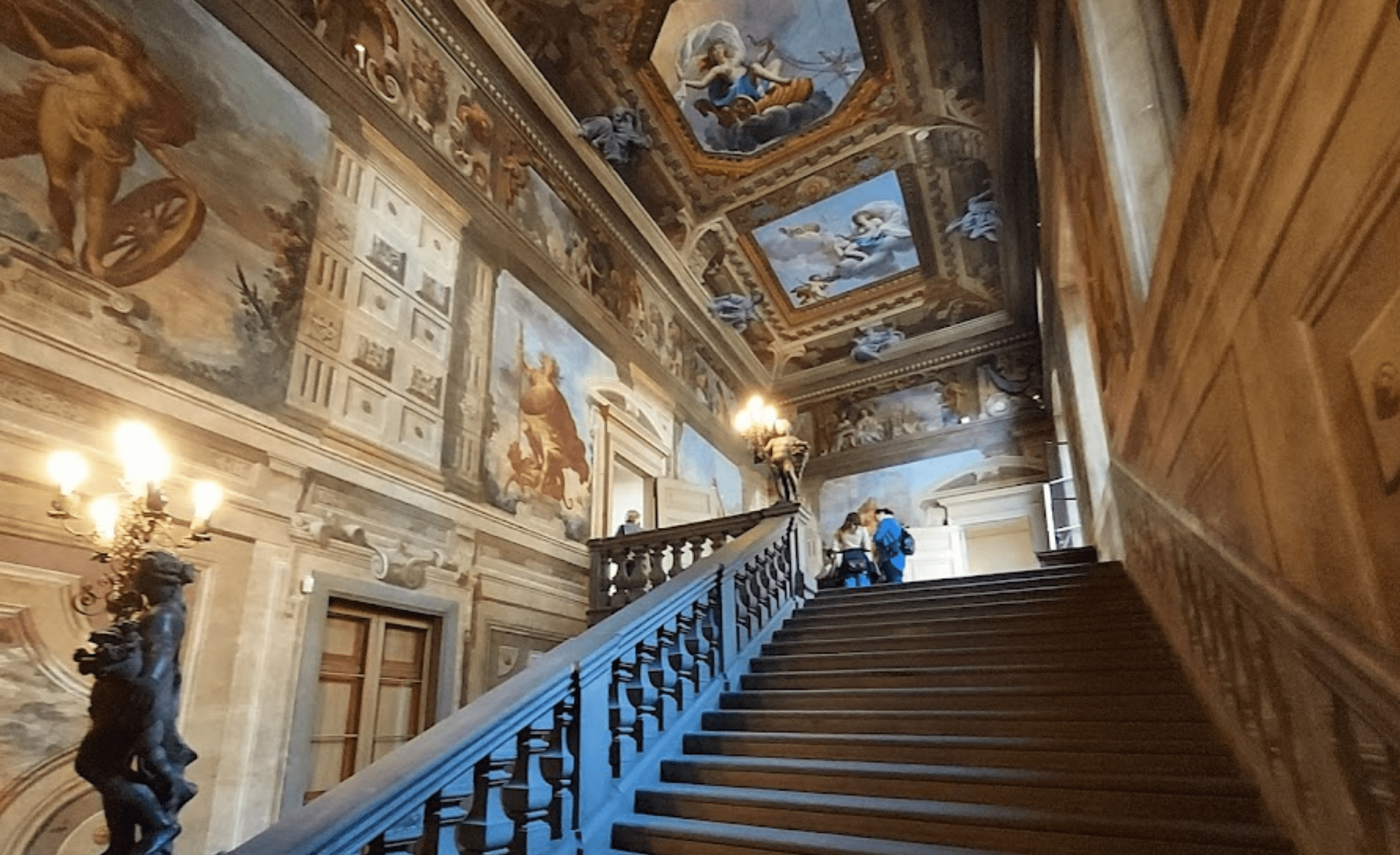 Elegant staircase with ornate ceiling murals.